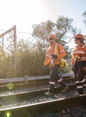 Rail workers walking along tracks.