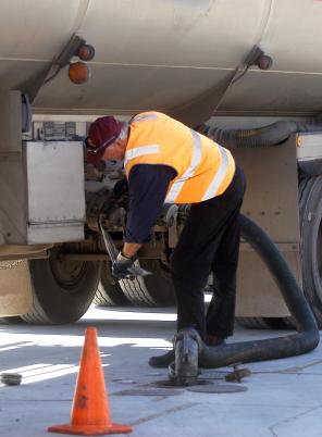 Truck driver refuelling truck.