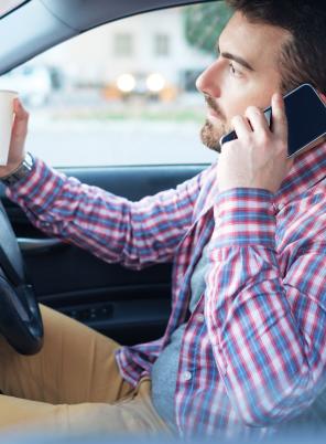 Driver on phone with coffee cup